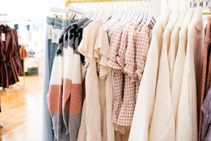 clothing rack of tops, dresses, sweaters and jeans