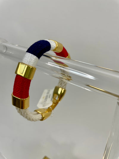 Navy blue, red, and white make up the pattern of this handmade rope bracelet with gold metallic accents and clasp to create a classic New England coastal bracelet.