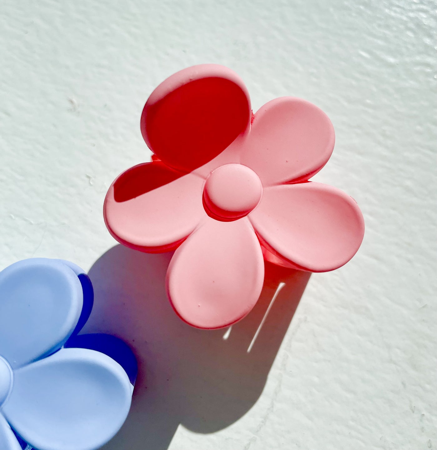 White, pink, and periwinkle colored flower small hair clips.